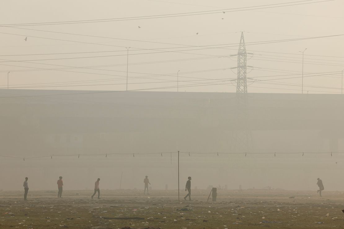 Men play cricket as the sky is enveloped with smog in New Delhi on November 20, 2024.