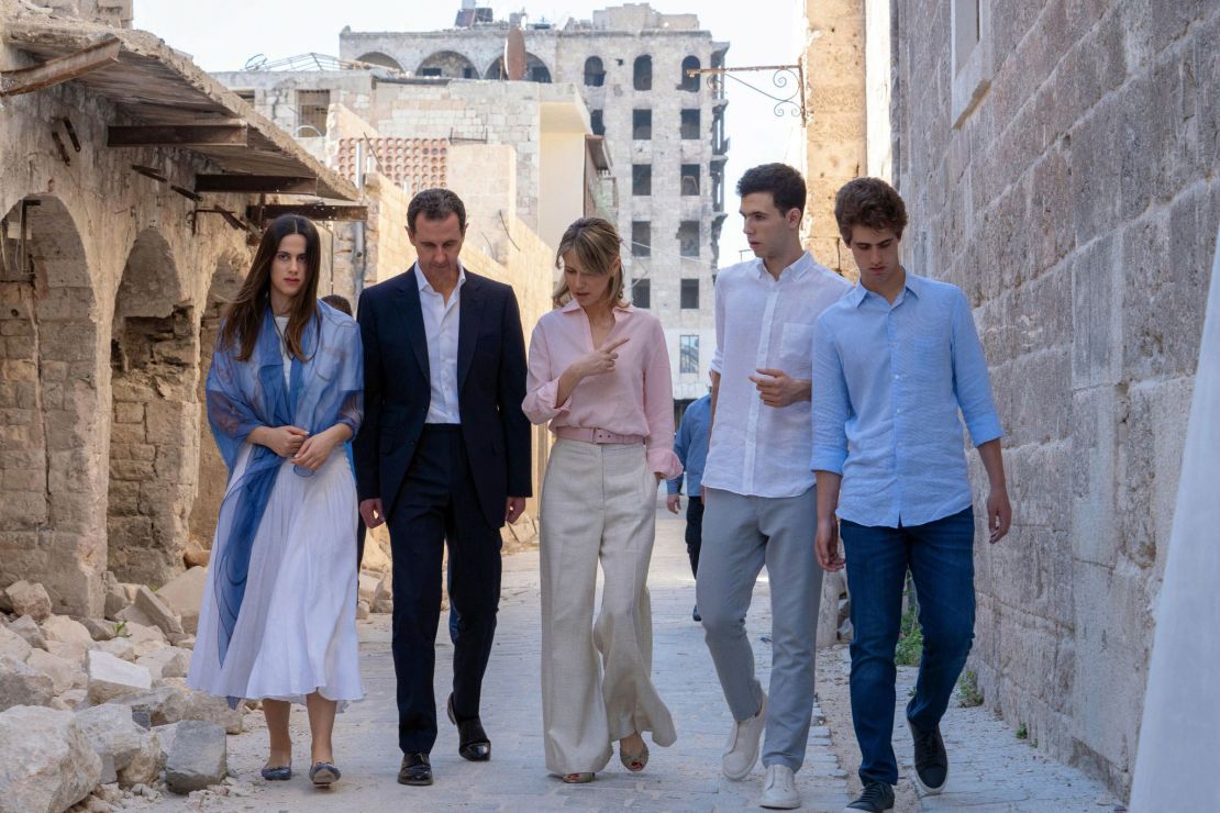 In this photo released on the official Facebook page of Syrian Presidency, Syrian President Bashar Assad, second left, and his wife Asma, center, and their children Zein, left, Karim, right, and Hafez walk outside the Great Mosque of Aleppo in the Old City of Aleppo, Syria, on July 8, 2022.