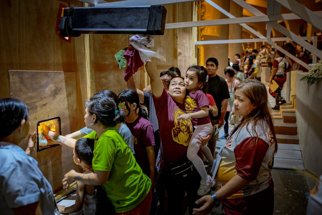 Filipino Catholic devotees queue to touch the Black Nazarene before its annual procession in Manila.